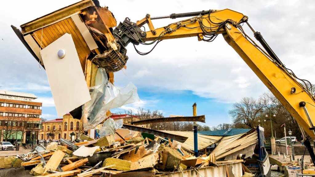 Worker removing drywall during light demolition.